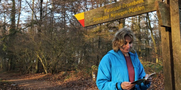 Wandelaar bij een wegwijzer met geel-rode markering © Luuk Gijselhart.JPG