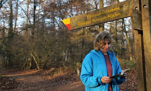 Wandelaar bij een wegwijzer met geel-rode markering © Luuk Gijselhart.JPG