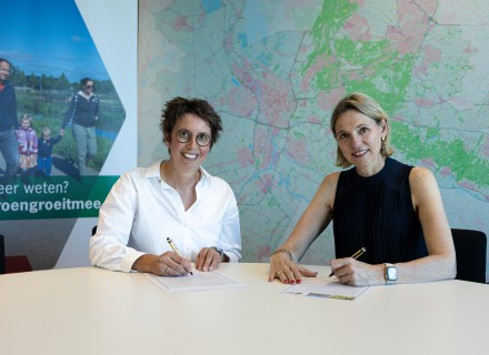 Ankie van Dijk (links) en Mirjam Sterk ondertekenen het Groen Groeit Mee Pact waarmee Wandelnet als Pactpartner toetreedt © WebNL